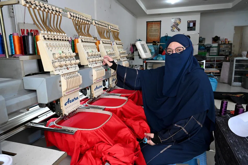 Cik Nur Asyiqin Jumuto menunjukkan salah sebuah mesin yang digunakan di kilang jahitnya di Batam – antara perniagaan yang beliau miliki bersama suaminya, Encik Ahmadi Yuswar.