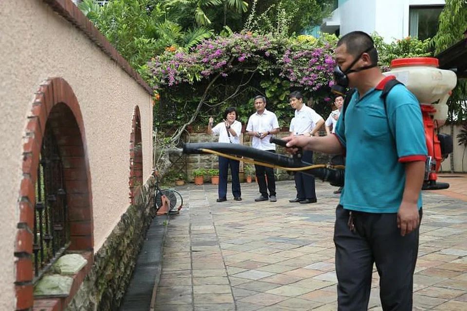 TINGKATKAN USAHA: Kerja menyembur kimia bagi mengekang pembiakan nyamuk terus dilakukan di Watten Estate semalam sambil disaksikan Menteri Ehwal Luar, Dr Vivian Balakrishnan (dua dari kiri), yang juga Anggota Parlimen GRC Holland-Bukit Timah. - Foto THE STRAITS TIMES