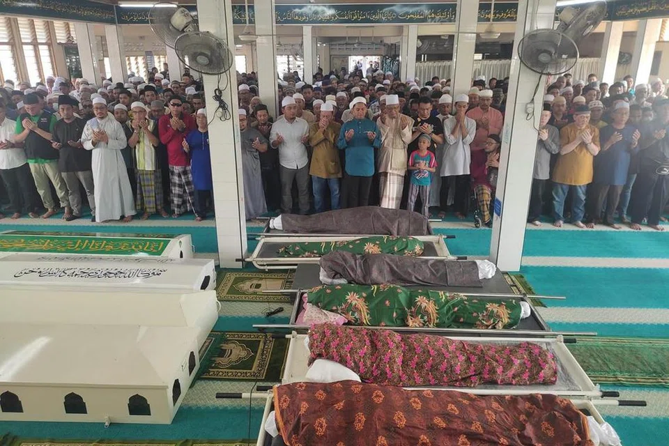 PENGHORMATAN TERAKHIR: Abdur Rahman Amir Ruddin (tengah berbaju biru) mengimamkan solat jenazah enam ahli keluarganya termasuk kedua ibu bapa yang maut dalam kemalangan di Kilometer 5, Jalan Segamat-Kuantan, Muar, Johor, pada petang Jumaat.