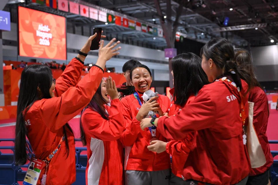 Kontinjen lawan pedang Singapura meraikan kejayaan pemenang pingat perak, Kiria Tikanah (tengah) selepas perlawanan akhir acara Epee Individu Wanita di Aichi Sky Expo Hall, Jepun, pada 22 September.