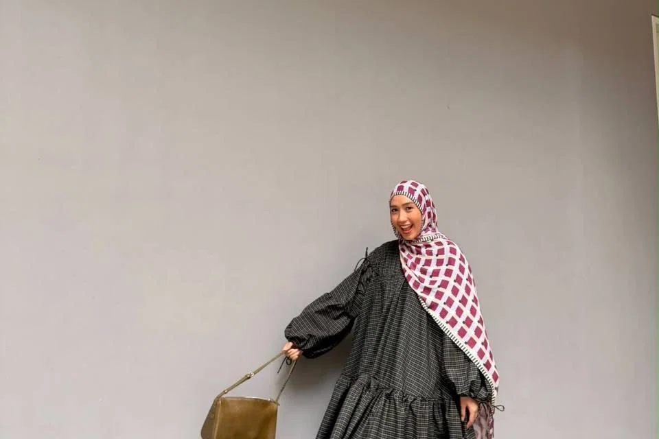 Cik Nur Hidayah Zait menggayakan pakaian longgar yang mencerminkan gaya peribadinya yang berwarna-warni dan berani, selain memberinya keselesaan serta ruang untuk bergerak dengan lebih bebas.