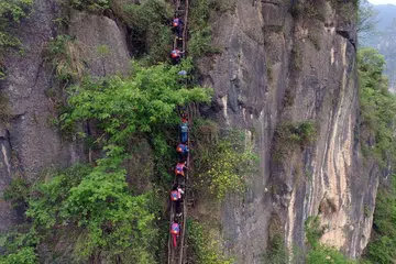 Kanak-kanak kampung Atuler mendaki anak-anak tangga kayu tua dan usang di tebing setinggi 800m untuk pulang ke rumah dari sekolah berasrama penuh mereka. 