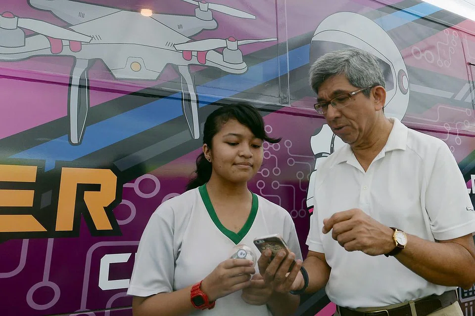 PUPUK DARI MUDA: Pelajar Amy Adrianna Azam (kiri) memperkenal projek robot berjoget, Sphero, kepada Dr Yaacob. - Foto TAUFIK A. KADER