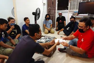 MEMBANTU: Keluarga mangsa kebakaran di Whampoa Blk 21 dibantu. - Foto TRUE HEARTS