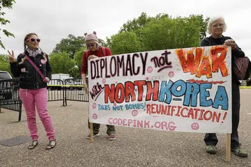 TOLAK PEPERANGAN: Aktivis mengadakan bantahan menentang peperangan dengan Korea Utara di depan Rumah Putih di Washington semalam. - Foto REUTERS