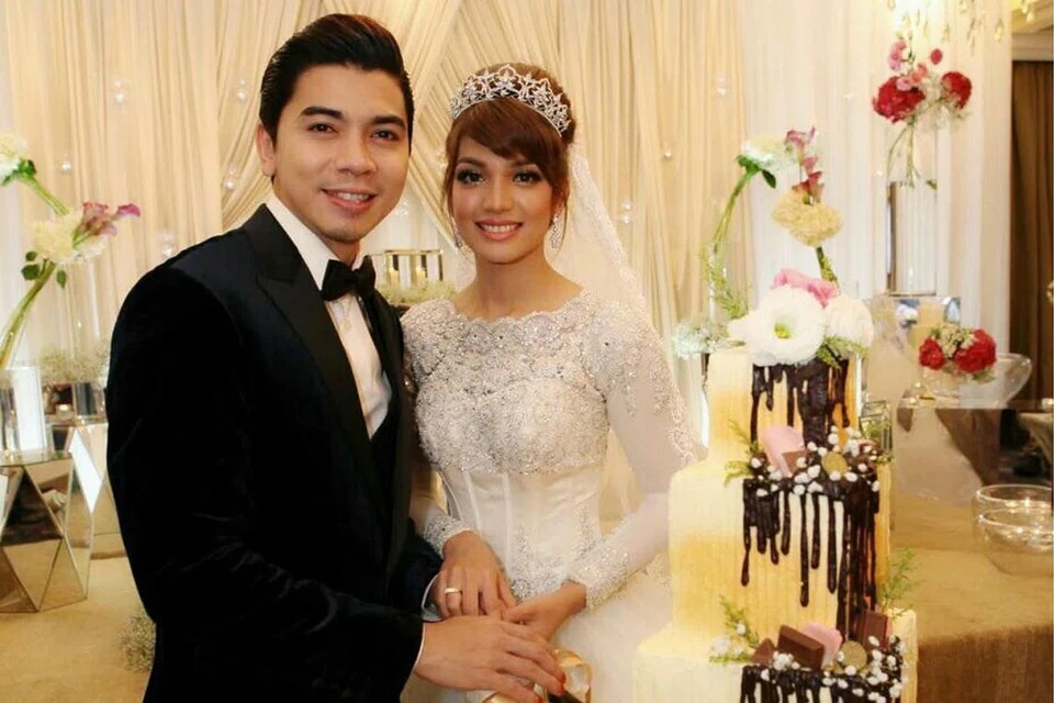 KEK EMPAT TINGKAT: Pasangan artis Amar Baharin dan Amyra Rosli dengan kek empat tingkat yang dihasilkan Cef Muhammad Haikal di majlis perkahwinan mereka di Singapura baru-baru ini. - Foto LIMCHING PHOTOGRAPHY