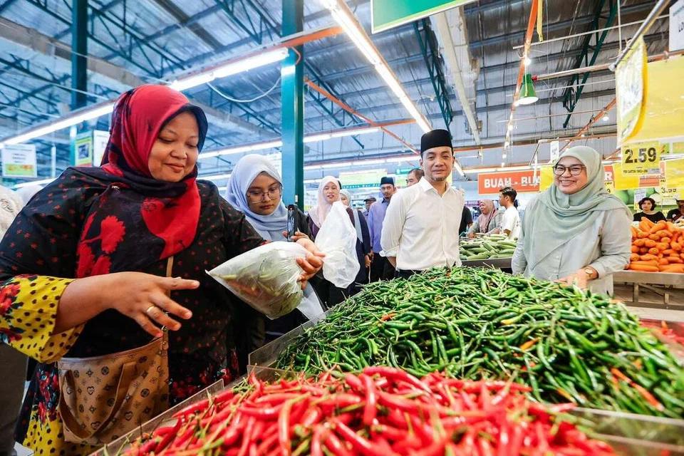 Menteri Besar Johor, Datuk Onn Hafiz Ghazi (dua dari kanan), memerhatikan orang awam membeli cili pada Program Bantuan Barang Dapur Majlis Agama Islam Negeri Johor.