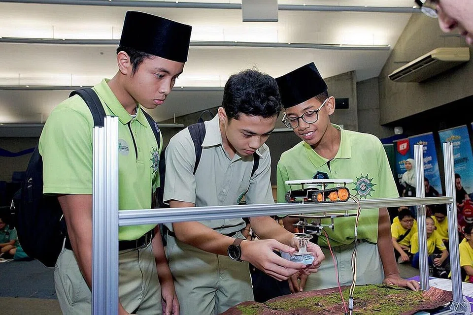 SEMANGAT BERKUMPULAN: Pelajar lelaki ini tekun berusaha membina 'land speeder' selepas menimba lebih banyak pengetahuan mengenai konsep-konsep Stem semasa mengikuti program 'Fuel Your School-Stem'. - Foto CDC CENTRAL
