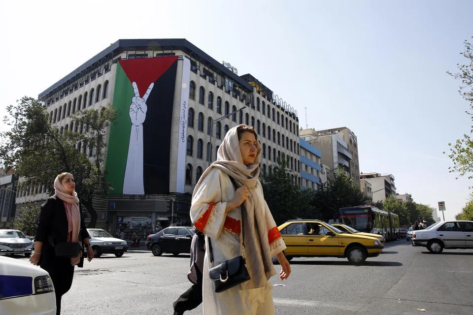 HENTIKAN DANA: Bendera Palestin bersaiz besar digantung pada sebuah bangunan di jalan raya Enghelab di Teheran. Pemerintah Iran menyokong secara terbuka serangan Hamas terhadap Israel. 