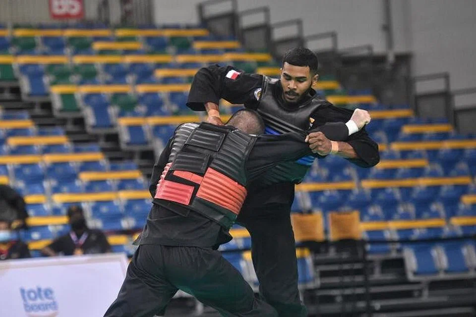 Pesilat negara Sheik Farhan Sheik Alau'ddin (kanan) menang acara tanding putera J (90-95 kilogram) senior di Kejohanan Pencak Silat Asia Tenggara 2022 di Dewan Satu OCBC Arena pada Ahad (27 Februari). - Foto BH oleh ARIFFIN JAMAR 