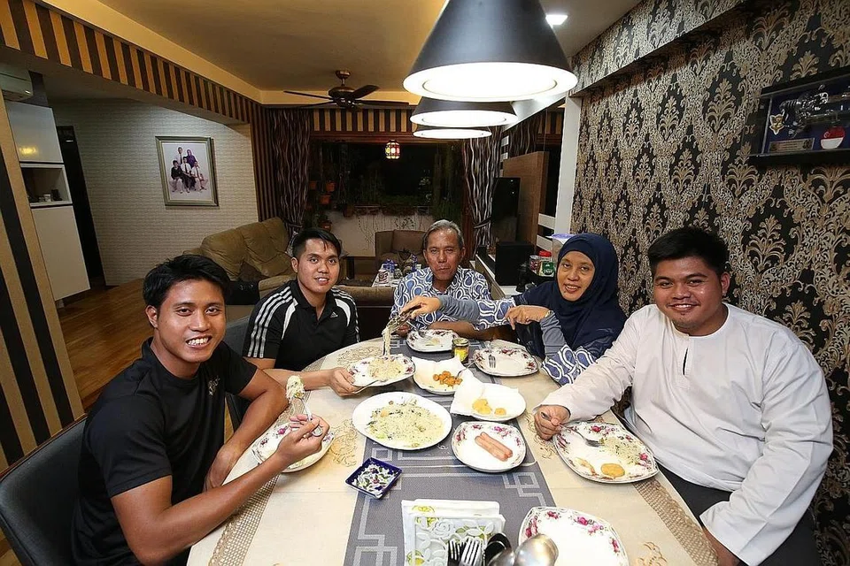 PULANG KE PANGKUAN KELUARGA: Encik Mohamad Fitri (dua dari kiri) kini banyak meluangkan masa bersama keluarga termasuk (dari kanan) adiknya, Encik Mohamad Nazri; ibu bapanya, Cik Hamidah dan Encik Mohamad Rashed; serta seorang lagi adiknya, Encik Mohamad Zakri, selepas jalani kuarantin 14 hari setelah pulang ke Singapura dari Wuhan. - Foto LIANHE ZAOBAO