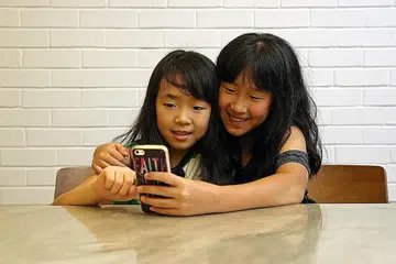 PENGGUNAAN TELEFON BIJAK: Tidak ada peraturan yang menetapkan usia seorang kanak-kanak sebelum dia menerima telefon bijak pertamanya, namun terdapat beberapa panduan yang berguna buat ibu bapa. - Foto fail