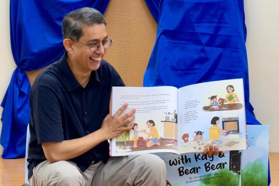 TERHIBUR SAMA: Dr Faishal kelihatan turut terhibur sama semasa membacakan buku cerita tersebut kepada kanak-kanak tersebut.