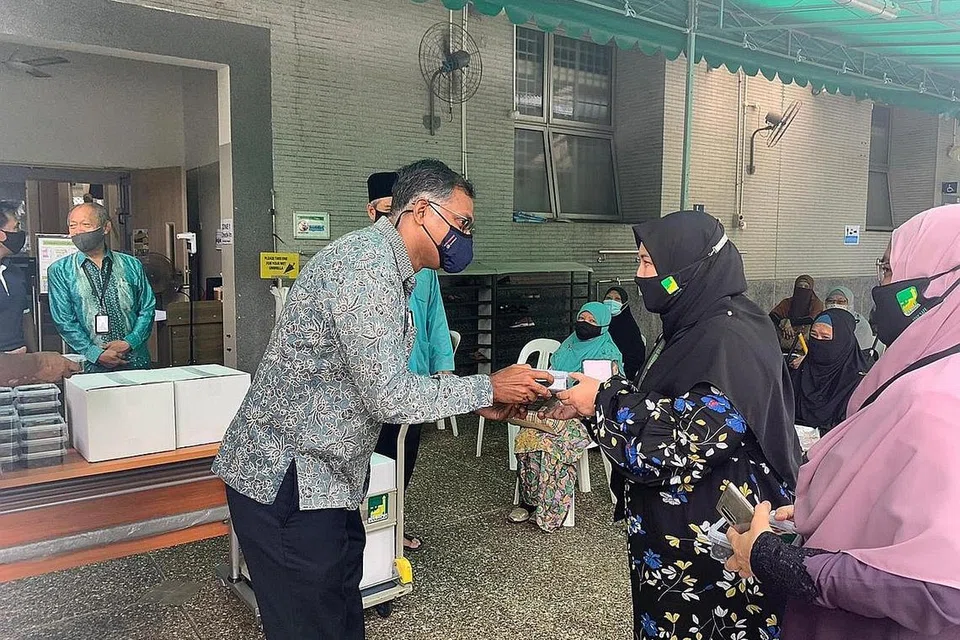 HADIAHKAN KURMA: Encik Murali, yang telah ke Masjid Ar-Raudhah kelmarin, mengagihkan kurma antaranya kepada kakitangan masjid tersebut sempena bulan Ramadan. - Foto MASJID AR-RAUDHAH