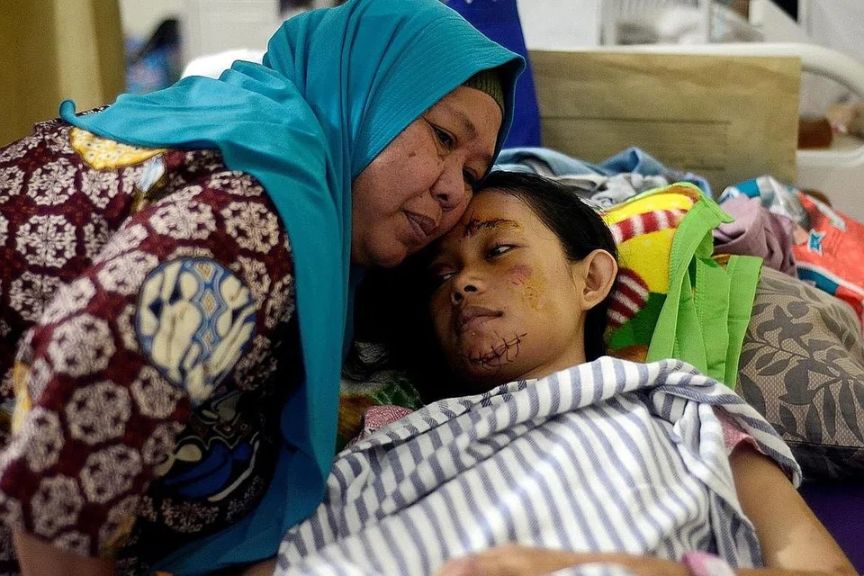 DIJAGA IBU: Seorang remaja perempuan yang cedera akibat tsunami, dipeluk ibunya sedang mangsa dirawat di sebuah hospital di Kalianda, Lampung, Indonesia. - Foto REUTERS