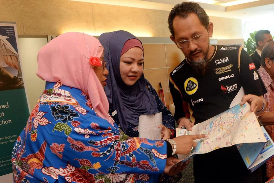 PAKAR PELANCONGAN JEPUN: Cik Khamisah Salamat (kiri) siap memakai 'Bingata' iaitu pakaian tradisional orang Okinawa ketika memberikan maklumat tentang tempat tersebut, termasuk tatatertib orang Okinawa, kepada para peserta Seminar Pelancongan Berita Harian. - Foto-foto TAUFIK A. KADER