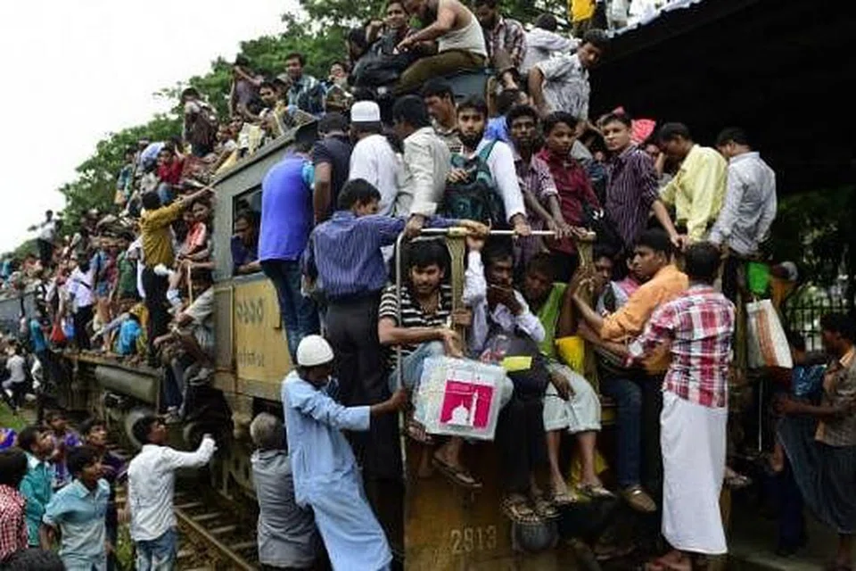 ADA RUANG LAGI KE?: Warga Bangladesh bergayut daripada setiap ruang yang ada pada kereta api dalam usaha mereka pulang ke kampung masing-masing untuk menyambut Aidilfitri. - Foto AFP 
