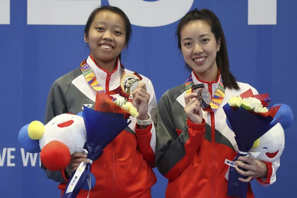 GENGGAM EMAS PADA KEMUNCULAN PERTAMA: Kiria (kiri) bersama rakan sepasukannya, Cheryl Lim, 26 tahun, pada majilis penyampaian pingat Sukan SEA ke-30 di Manila bulan lalu.