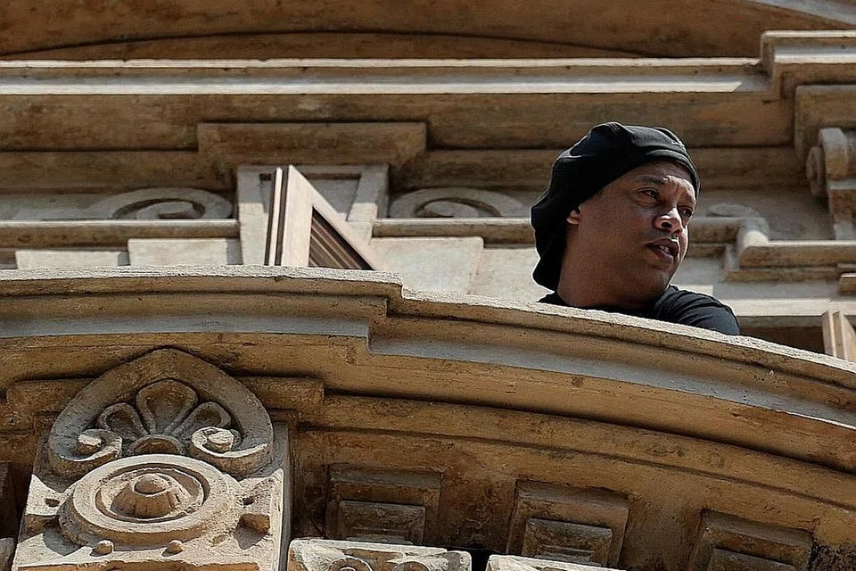 DITAHAN: Ronaldinho dilihat Isnin lalu di balkoni sebuah hotel mewah tempat dia diletak di bawah tahanan dalam rumah selama empat bulan di Asuncion, Paraguay. Beliau telah dibebaskan dengan bersyarat minggu lalu. - Foto REUTERS 