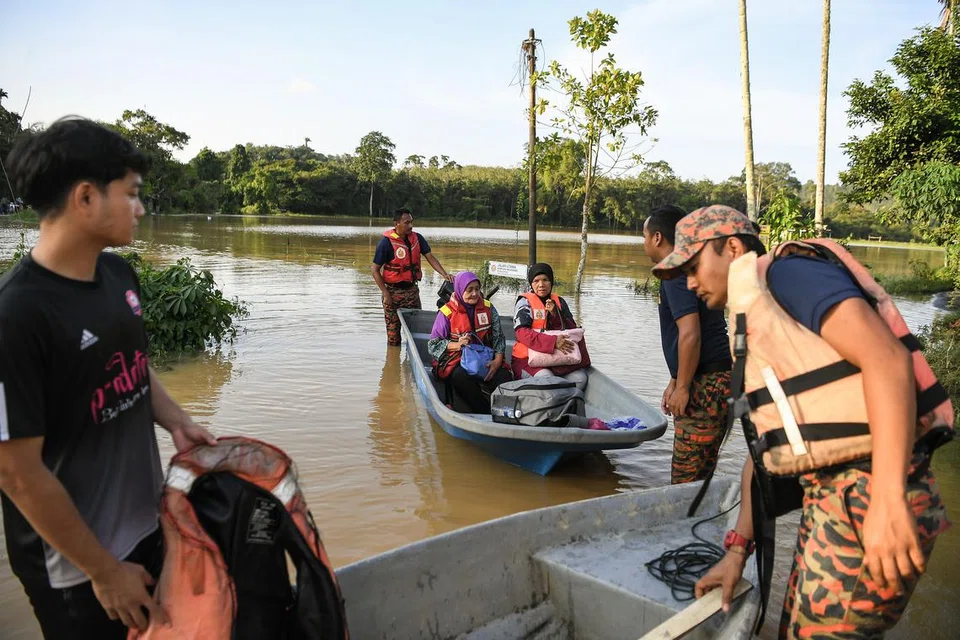 Anggota Bomba dan Penyelamat Malaysia menjalankan operasi membawa keluar mangsa banjir dari rumah mereka yang terputus hubungan akibat banjir kali kedua di Kampung Derang di Kedah.
