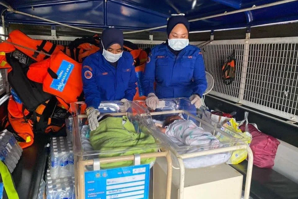 SELAMATKAN BAYI: Empat bayi dan dua kanak-kanak lelaki dari Hospital Hulu Terengganu, Terengganu, diserahkan kepada keluarga mereka dengan bantuan Angkatan Pertahanan Awam Hulu Terengganu, selepas laluan terputus akibat banjir.
