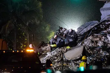 LEBIH RAMAI DIKHUATIRI MAUT: Pekerja menyelamat menarik keluar sekujur mayat dari runtuhan kondominium itu kelmarin. Jumlah korban dijangka bertambah kerana 99 penduduk belum dapat dihubungi hingga petang kelmarin. - Foto