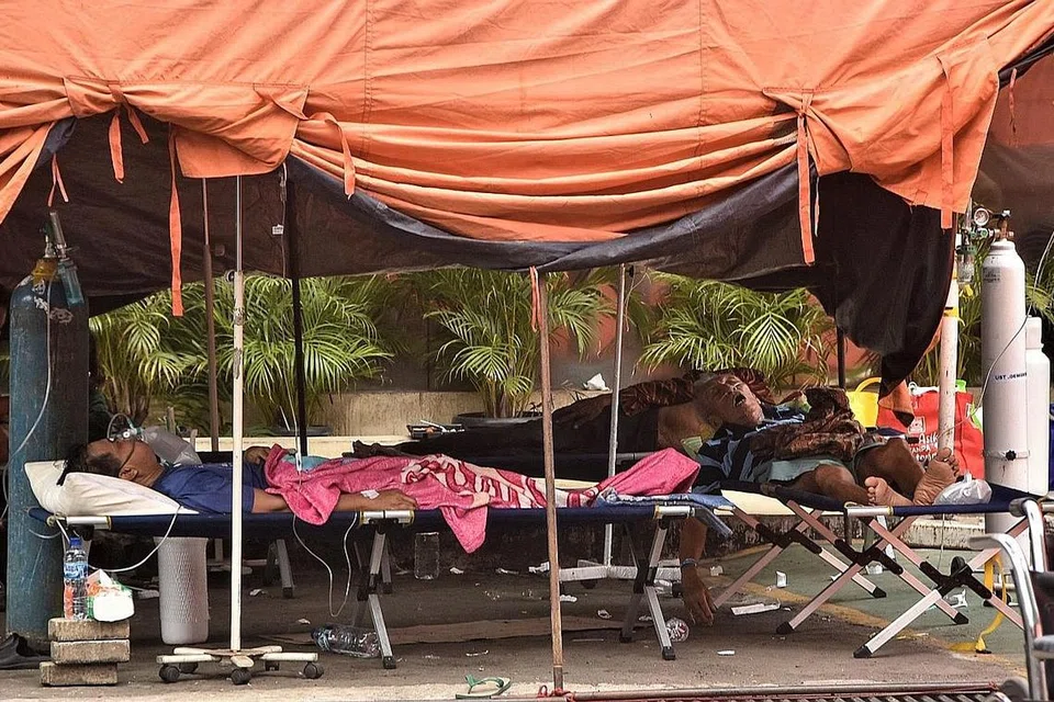 DIRAWAT DI KHEMAH: Sebilangan pesakit koronavirus Covid-19 dirawat dan ditempatkan di khemah yang terletak di sebuah hospital di Bekasi, Jawa Barat, ekoran kekurangan tempat katil di hospital serata Indonesia. - Foto AFP