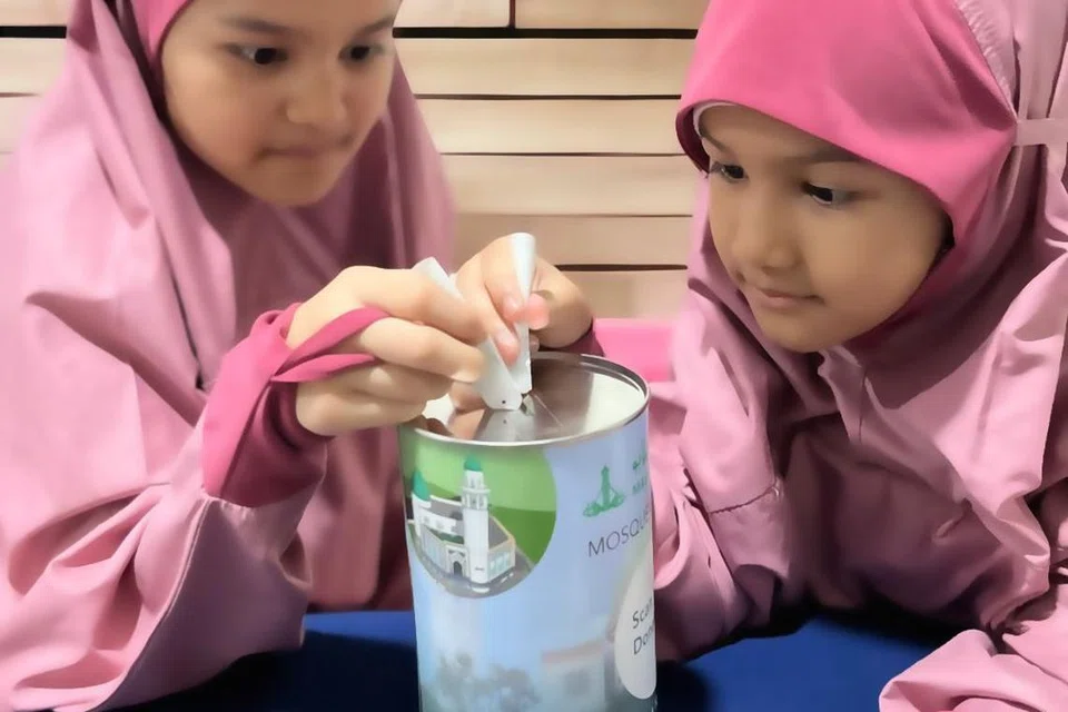 MENABUNG UNTUK MASJID: Melalui projek lnfaq Fajar anjuran Masjid Alkaff Kampung Melayu, penderma boleh membawa pulang tabung derma yang diberikan pihak masjid agar seisi keluarga termasuk anak-anak kecil, dapat menyumbang sama.