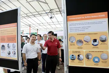 Menteri Pembangunan Negara, Encik Desmond Lee (kiri), dan Anggota Parlimen GRC West Coast, Encik Ang Wei Neng, mengunjungi pameran mengenai program naik taraf bagi kawasan Nanyang di Jurong West pada 28 Julai.