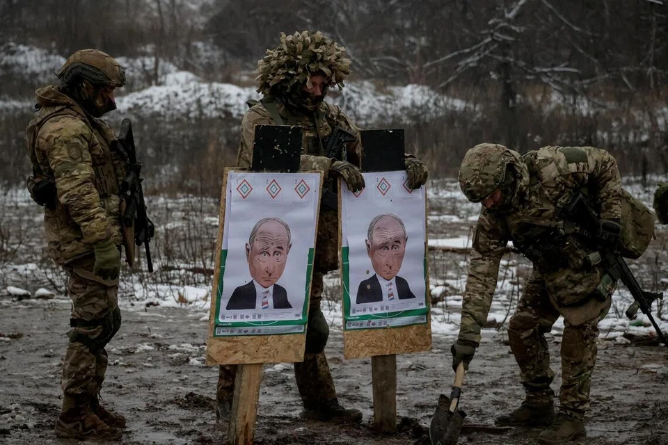 Anggota Briged Tujuan Operasi ke-13 ‘Khartiia’ dari Pengawal Kebangsaan Ukraine memasang sasaran imej Presiden Russia Vladimir Putin semasa latihan menembak, di  wilayah Kharkiv, Ukraine, 10 Disember 2025.  