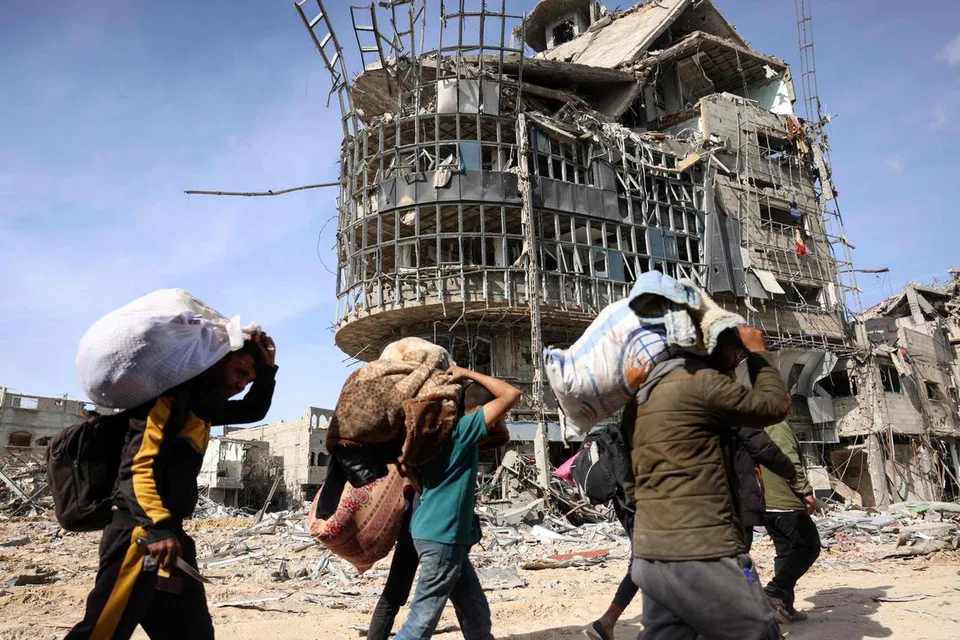Penduduk Palestin yang kehilangan tempat tinggal membawa barang-barang milik mereka sambil berjalan di tengah-tengah kehancuran ketika kembali ke Rafah tengah di selatan Semenanjung Gaza pada 19 Januari 2025, selepas gencatan senjata antara Israel dan Hamas berkuat kuasa. 