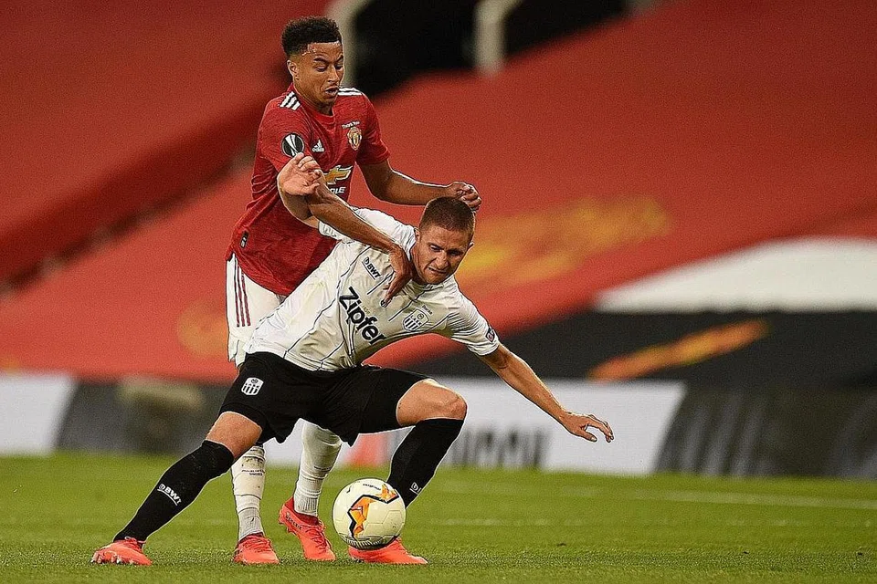 PENDORONG: Pemain Manchester United Jesse Lingard (jersi merah) dan pemain LASK Reinhold Ranftl berebut bola. Lingard menyamakan kedudukan 1-1, menyemarakkan United untuk menang. - Foto AFP
