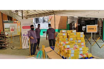 TERUS DEKATI MASYARAKAT: Petugas dan relawan Masjid Al-Amin (dari kiri), Encik Mohamed Kassim Abdul Hamid, Encik Johari Mohamed Sainee dan Encik Ali Ahmad sedang mempersiap laluan masuk dan keluar masjid di zon-zon yang tersedia beserta minuman air kotak dan mineral untuk diambil para jemaah sewaktu pulang dari solat Jumaat. - Foto MASJID AL-AMIN.