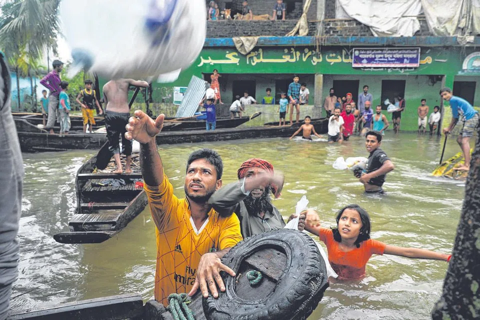 BANGLADESH: MANGSA BANJIR DI BANGLADESH: Para penduduk yang terjejas terpaksa meredas banjir untuk mendapatkan bekalan yang terputus, sementara di daerah dan wilayah lain, berjuta orang mengalami kesulitan mendapatkan bekalan makanan. - Foto AFP