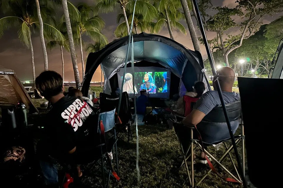Keluarga Cik Ridya Wati Mohamed Ibrahim, yang berkhemah dan bermalam di Pantai East Coast pada 9 Ogos, menonton filem seram menggunakan projektor.