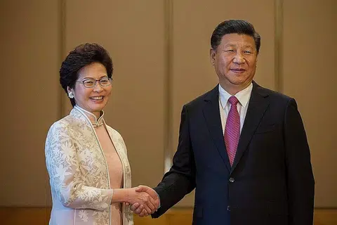 TAHNIAH: Presiden China Xi Jinping berjabat tangan dengan Ketua Eksekutif Hongkong yang baru, Cik Carrie Lam, semasa pertemuan mereka di Hongkong semalam. - Foto AFP