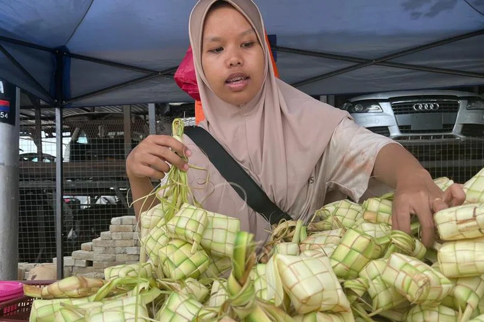 Cik Irna Nur Awi, 23 tahun, menjual daun ketupat yang siap dianyam bermula tiga hari sebelum Aidilfitri di Hulu Klang, Selangor.