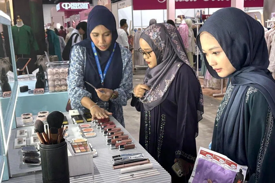 Penyelia Operasi Yumi Basics dari Singapura, Cik Siti Zubaidah Omar (kiri), melayani pelanggannya memilih kosmetik di Absolut Bazaar Gaya Raya di Kuala Lumpur. 