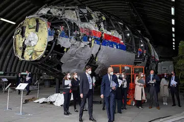 PERIKSA PESAWAT: Gambar yang diambil pada 26 Mei ini menunjukkan Hakim Hendrik Steenhuis (tengah), disertai hakim dan peguam lain sedang melihat bangkai pesawat Malaysia Airlines MH17 yang dibina semula, di sebuah pangkalan udara. - Foto AFP