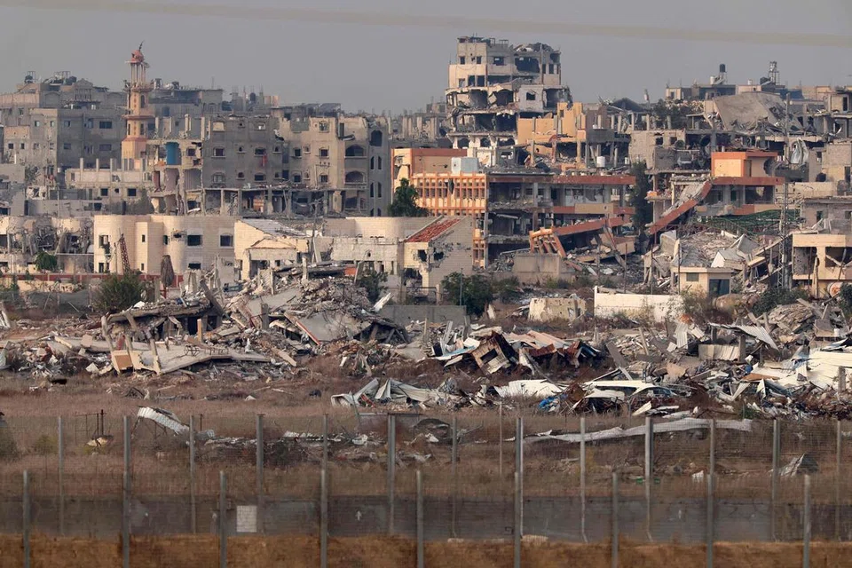 Gambar yang diambil daripada selatan sempadan Israel pada 11 Disember menunjukkan bangunan-bangunan yang menyembah bumi akibat serangan Israel di wilayah Gaza.