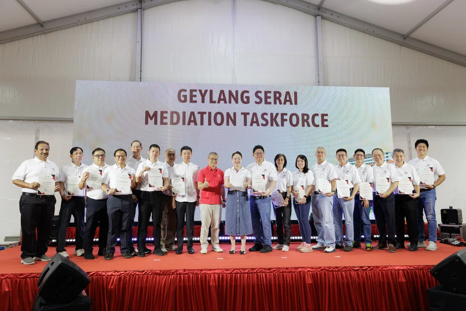 Menteri Undang-Undang, Encik Edwin Tong (sembilan dari kiri) dan Anggota Parlimen (AP) GRC Marine Parade-Braddell Heights, Cik Diana Pang (tengah) bersama Pasukan Petugas Pengantaraan Geylang Serai yang baharu di Haig Road pada 27 September.
