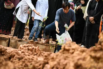 SELAMAT DIKEBUMI: Suami Allahyarhamha Nur Aisyah Md Akbar, Encik Abdul Rauf Mohd Said, menabur bunga di atas pusara arwah isterinya selepas selesai pengebumian di Pusara Aman pada 27 Disember.
