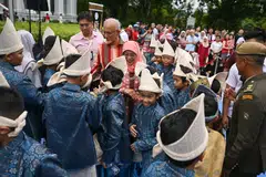 SAMBUTAN MESRA: Presiden Halimah Yacob (tengah) dan suaminya, Encik Mohammed Abdullah Alhabshee (di belakang Puan Halimah) beramah mesra dengan murid-murid dari Madrasah Irsyad Zuhri Al-Islamiah yang membuat persembahan dikir barat. 