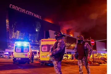 Pegawai penguatkuasa undang-undang mengawal di luar bangunan konsert, Dewan Bandaraya Crocus, yang terbakar berikutan serangan pengganas pada Jumaat. 