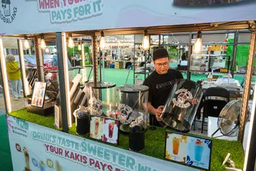Pemilik gerai minuman GoBalang SG, Encik Muhammad Ismail Yunus, mempersiapkan gerai beliau yang merupakan antara 500 gerai di Bazar Raya Geylang Serai 2025. 