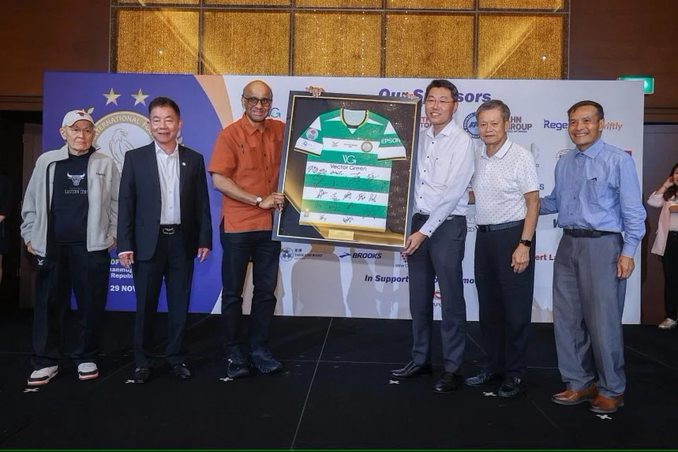 Penasihat Geylang International, Encik Ben Teng (tiga dari kanan), menyampaikan jersi kepada Presiden Tharman Shanmugaratnam (tiga dari kiri) di majlis jamuan malam sempena jubli emas kelab bola sepak itu bersama (dari kiri) pengasas, Encik Colin Ng; pengerusi, Encik Thomas Gay; serta mantan pengerusi, Encik Patrick Ang dan Encik Leong Kok Fann.