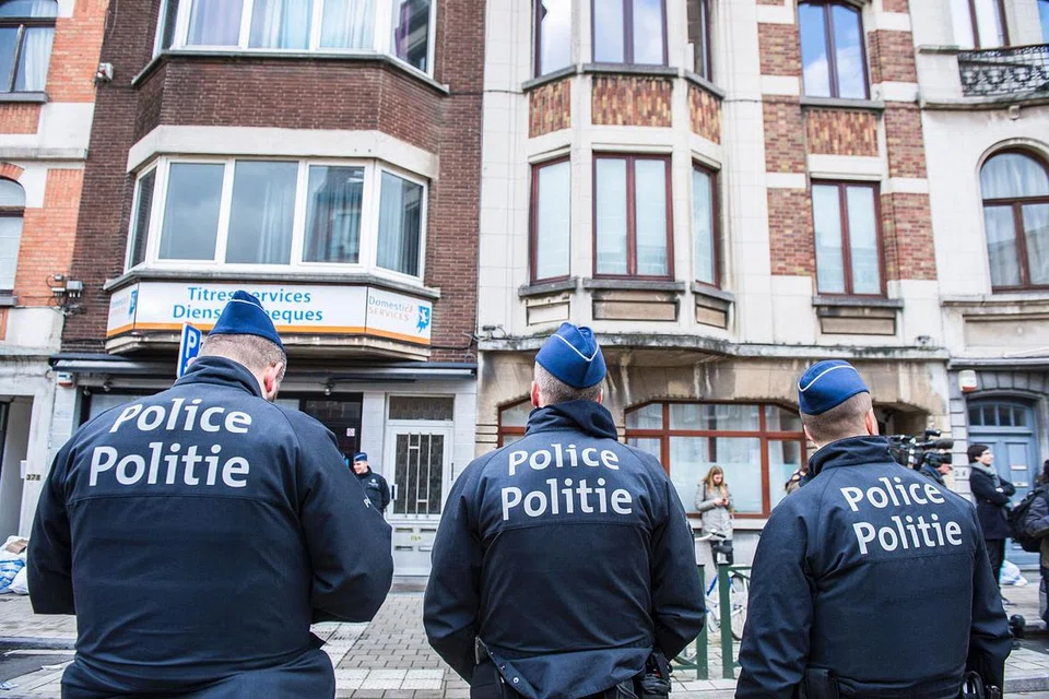 OPERASI MEMBURU DITERUSKAN: Pegawai polis berjaga-jaga di kejiranan Schaarbeek di mana seorang suspek telah ditembak. - Foto AFP