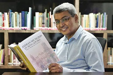 BAKTI KEPADA MASYARAKAT: Dr Ab Razak yang diiktiraf dengan Anugerah Jasa Cemerlang Muis tahun ini bersama buku tulisannya yang dilancar baru-baru ini yang menyusur sejarah, warisan serta sumbangan masyarakat India Muslim di Singapura.
