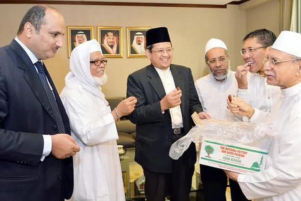 KURMA PERERAT HUBUNGAN: Habib Hassan (kanan) menawarkan kurma barny dari Madinah kepada Setiausaha Pertama Kedutaan Arab Saudi, Encik Saleh Abdullah A Alnuaiser (kiri) dan juga tetamu lain (dari kiri), mantan Mufti Syed Isa Semait; Mufti Dr Fatris Bakaram; Sheikh Muhammad Albaiti dan Dr Maliki Osman. - Foto KHALID BABA