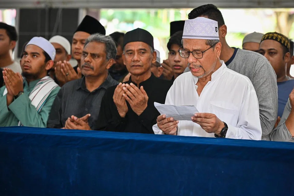 Encik Mohamed Kassim Yusoff (paling kanan), datuk kepada Allahyarhamha Afifah Munirah Muhammad Azril, mengimamkan sembahyang jenazah di kediaman arwah di Pasir Ris Street 71 sebelum upacara pengebumian di Pusara Aman pada 23 April.
